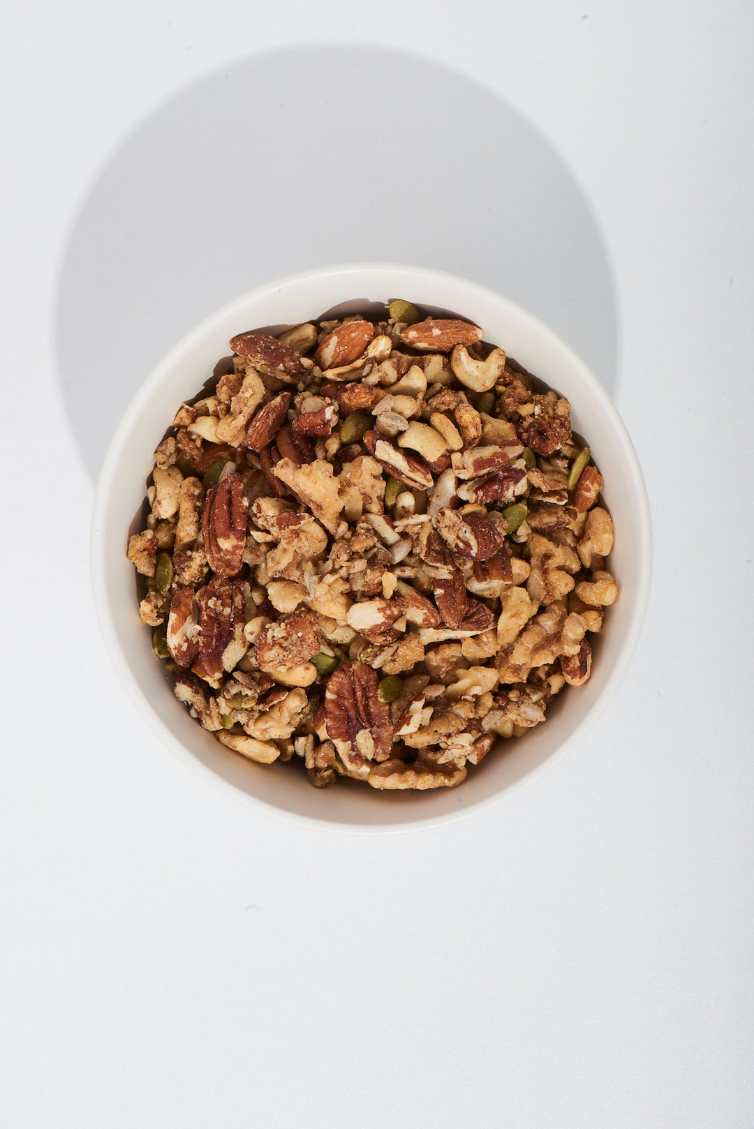 White bowl filled with granola on a white background