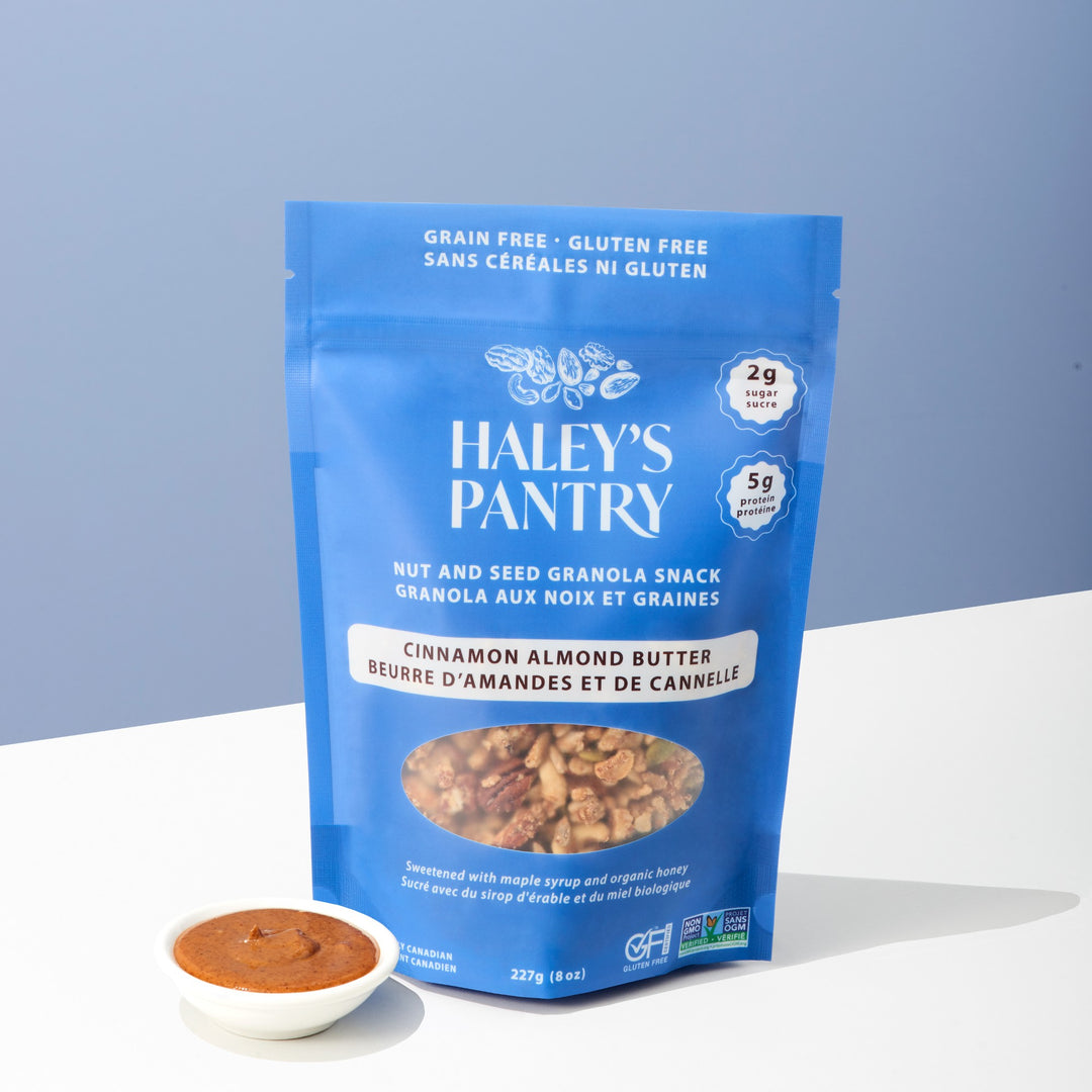 Haley's Pantry cinnamon almond butter snack package with a small bowl of the product on a light blue background